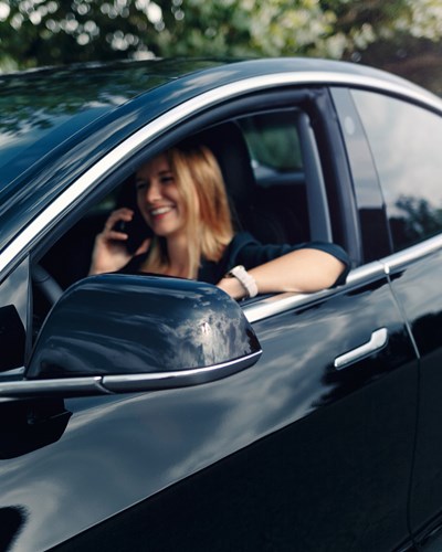 Woman Sitting In Tesla Car On The Phone