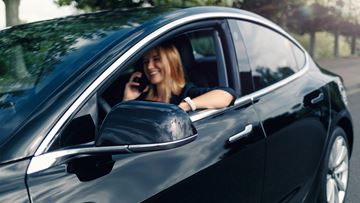 Woman Sitting In Tesla Car On The Phone