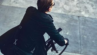man in zwarte jas op een fiets